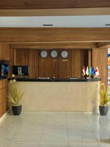 un hall avec des horloges sur le mur et un comptoir dans l'établissement Pyramids hotel Merak, à Banī Ghālib 90 autres photos