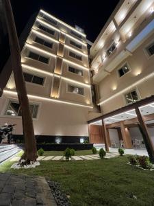 Un gran edificio con una palmera delante. en Pyramids hotel Merak, en Banī Ghālib 95 fotos más