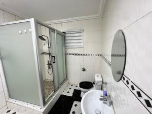 a bathroom with a sink and a shower and a toilet at Manresa House in Accra +6 photos