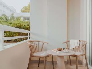 Hyde Hotel Ibiza Beach Resort by ACCOR في كالا يونغا: طاولة صغيرة و كرسيين على شرفة +240 صورة