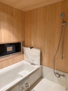 The Guest House Japan Hakuba في هاكوبا: حمام صغير مع حوض استحمام وميكروويف +143 صورة
