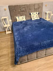 una camera con un letto blu e due sgabelli di Vila Sebas a Zărneşti