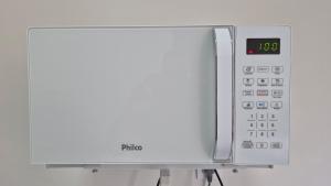 a white microwave oven with a clock on it at AP Completo, Bem Localizado, Próx Hospital Haroldo Tourinho, Ar-Condicionado in Montes Claros