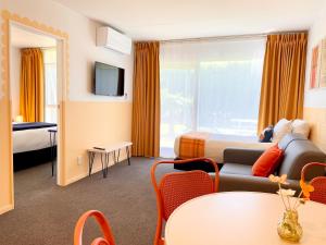 Mount Eden Motel في أوكلاند: غرفة فندق مع أريكة وسرير