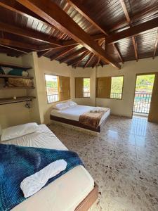 Hospedaje Doña Blanca 2 في Concepción: سريرين في غرفة ذات سقف خشبي ونوافذ