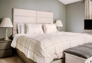 una camera da letto con un grande letto bianco con due lampade di The Overlook at Interlaken a Lake Como