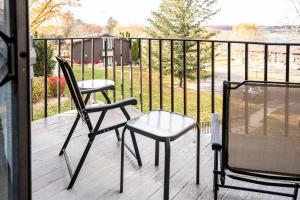 due sedie sedute su un ponte con recinto di The Overlook at Interlaken a Lake Como