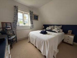 a bedroom with a white bed and a window at Silsoe Cottage B&B in Silsoe