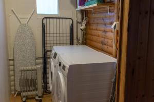 Una lavadora y secadora en una habitación con ventana. en Dreamy Cabin with Sea Views, North Iceland, en Bakkafjörður