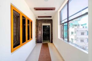Un pasillo vacío con una puerta y ventanas. en Hotel O Surya Teja Residency, en Khammam