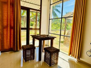 a table in a room with a large window at White House Safari Cottage in Udawalawe