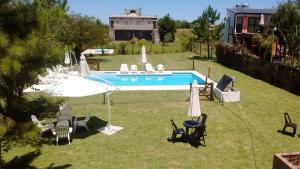 a swimming pool in a yard with chairs and umbrellas at Cabañas Las Victorias in Colón