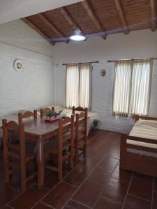 a dining room with a table and chairs and a bed at Cabañas Las Victorias in Colón