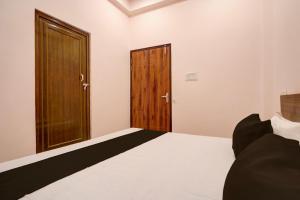 um quarto com uma cama e 2 portas de madeira em Hotel O Haven Palace em Alambagh