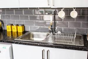 eine Küchenspüle mit einem Abtropfgestell daneben in der Unterkunft Central Location! 15 mins to Airport 2 mins to High Street and Station FREE PARKING!! in Birmingham + 61 Fotos