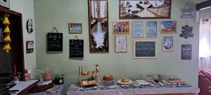 a wall with a table with food and pictures on it at Casa Strela Jericoacoara in Jericoacoara