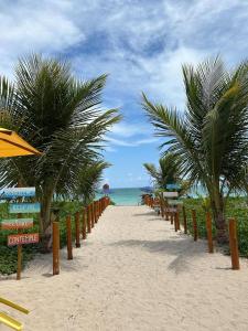 ein Strand mit Liegestühlen und Sonnenschirmen und das Meer in der Unterkunft Fonte dos Corais - Suíte Brisa da Tarde in Maragogi
