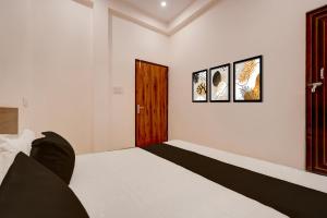 um quarto com uma cama e dois quadros na parede em Hotel O Haven Palace em Alambagh