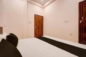 um quarto com uma cama e uma porta de madeira em Hotel O Haven Palace em Alambagh