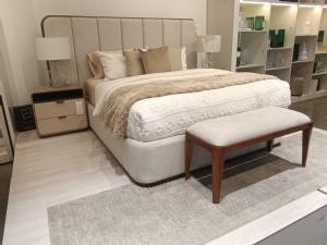 a bedroom with a large bed with a bench and a stool at Hermoso departamento de tres dormitorios in Cuenca