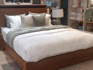 a large bed with white sheets and pillows at Hermoso departamento de tres dormitorios in Cuenca