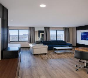 ein Wohnzimmer mit einem blauen Sofa und einem Tisch in der Unterkunft Hotel Pergola Jamaica JFK in Queens