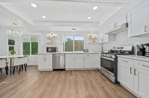 eine Küche mit weißen Schränken und einem Tisch mit einem Esszimmer in der Unterkunft Marbella Lane Modern Home w Private Backyard in La Habra