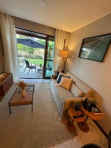 una sala de estar con un sofá y una mesa en Aprto luxo ILOA barra de São Miguel com enxoval, en Barra de São Miguel