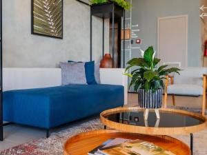 拉夫拉斯ibis Lavras的客厅里有一张蓝色的沙发和一张桌子
