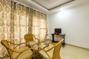 Palm Beach Resort, Alleppey في أليبي: غرفة بها كراسي وطاولة وتلفزيون