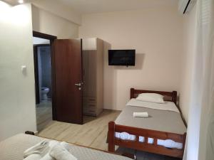 a small bedroom with two beds and a television at Harmony Apartments in Larisa +216 photos