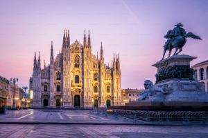 a statue in front of a building with a cathedral at Milan Luxury Loft with Sauna & Jacuzzi in Milan