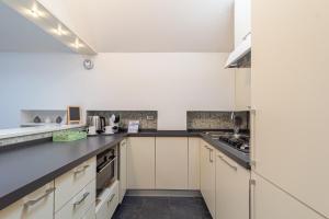 a kitchen with white cabinets and black counter tops at Il camino felice - 201 by Houset in Monza +13 photos