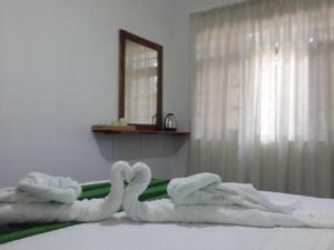 a bed with two swans made out of towels at White House Safari Cottage in Udawalawe +51 photos