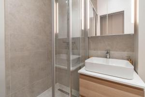 a bathroom with a white sink and a shower at Charmante Suite - LSP le Marais in Paris