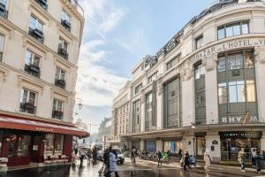 a group of people walking on a city street with buildings at Charmante Suite - LSP le Marais in Paris