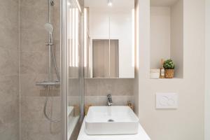 a bathroom with a sink and a shower at Charmante Suite - LSP le Marais in Paris