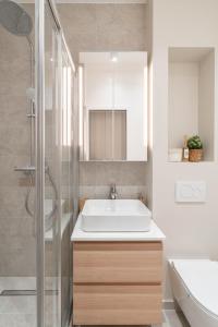 a bathroom with a white sink and a shower at Charmante Suite - LSP le Marais in Paris