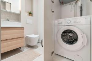 a bathroom with a washing machine and a sink at Charmante Suite - LSP le Marais in Paris +11 photos