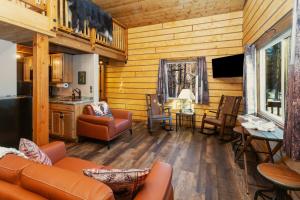 a living room with a couch and a table and chairs at Riverfront, Authentic, Luxury Log Cabin-Bull Moose in Wasilla