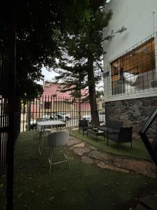 Hostal Casa Herrera في غواذالاخارا: فناء مع طاولة وكراسي بجوار سياج