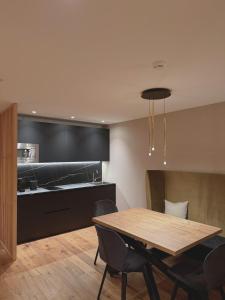 NEW OPENING LA TRUGA Suite Apartments في سيلفا دي فال جاردينا: مطبخ وغرفة طعام مع طاولة وكراسي +29 صورة