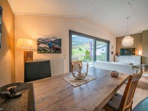 a living room with a table and a large window at Tauernhaus Madelief in Piesendorf