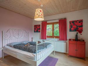 a bedroom with a white bed and red curtains at Tauernhaus Madelief in Piesendorf