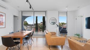 a living room with a dining room table and chairs at District Apartments Fitzroy in Melbourne