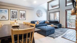 Cloud 9 by AvantStay Located at the Base of Vail Ski Resort w Community Pool Hot Tub في فيل: غرفة معيشة مع أريكة زرقاء وطاولة