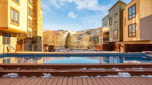 Cloud 9 by AvantStay Located at the Base of Vail Ski Resort w Community Pool Hot Tub في فيل: حمام سباحة في وسط مبنى به جبال