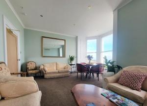 a living room with chairs and a table and a mirror at Kings House in Douglas