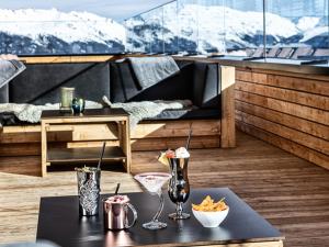 a room with a table with drinks on a balcony at Mountain View Loft Bergkristall in Kaltenbach