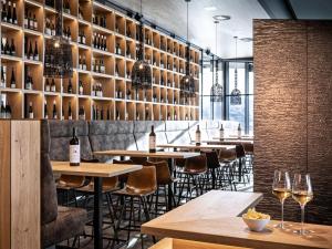 a restaurant with tables and wine bottles on the wall at Mountain View Loft Bergkristall in Kaltenbach